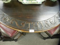 An antique oak oval gateleg table the edge carved 'Give us this day our daily bread', 127 cms