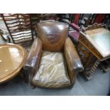 A pair of old brown leather Club armchairs on bun feet