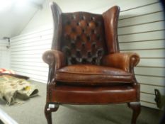 A red leather wingback armchair, having deep buttoned back, on cabriole legs