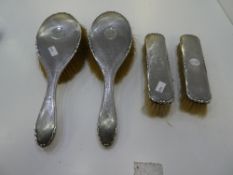 A silver dressing table set of four, consisting of all brushes. Having a central cartouche