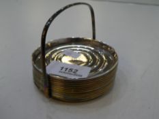 A quantity of twelve silver coasters and a holder. Marked sterling. Total weight approx 7.51ozt