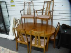 A 1970s teak extending dining table with concealed leaf and a set of six chairs, two having open