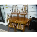 A 1970s teak extending dining table with concealed leaf and a set of six chairs, two having open