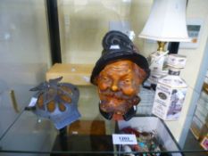 A 19th century pottery tobacco jar of continental bearded man, an AA car badge and sundry