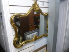 A decorative wall hanging mirror in a gilt frame