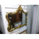 A decorative wall hanging mirror in a gilt frame