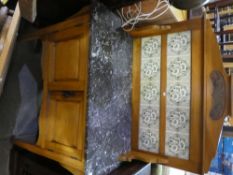 Pine washstand with marble top above cupboards and a tile back