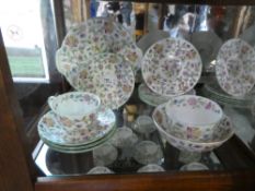 A collection of Minto tea ware depicting garden flowers, including cups, saucers, plates, sugar bowl