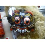 An Asian style mask with long straw like hair and another mask