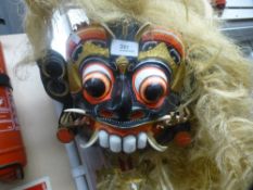 An Asian style mask with long straw like hair and another mask