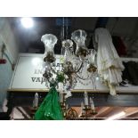 Decorative ceiling light with 5 branches and tall glass shades and a central shade.