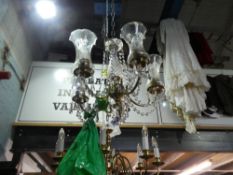 Decorative ceiling light with 5 branches and tall glass shades and a central shade.