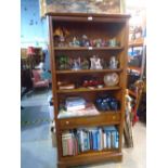 A dark cherrywood bookcase with a central drawer