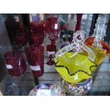 Shelf of cut coloured glass to include baskets, cups, decanter and jug, etc