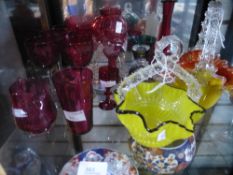 Shelf of cut coloured glass to include baskets, cups, decanter and jug, etc