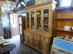 Large country pine display dresser with a glass doors above cupboards