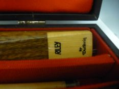 A Riley Snooker cue in a case by Dufferin, two others - one by BCE and the other by Ronnie O'