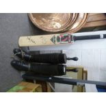 A pair of old black leather riding boots with stretchers and a Cricket bat with two signatures