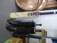 A pair of old black leather riding boots with stretchers and a Cricket bat with two signatures