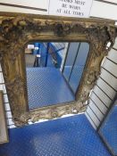 An antique gilt wall mirror with ornate frame, 76.5cms
