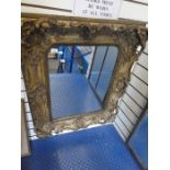 An antique gilt wall mirror with ornate frame, 76.5cms