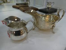 Two silver jugs, one being hallmarked London 1933, Pearce & Sons Ltd, Silversmiths, dented, together