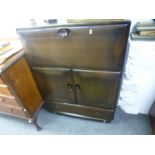 An Ercol dark oak sideboard having cupboards and drawers, and a similar smaller example