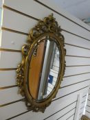 An oval gilt mirror