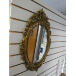 An oval gilt mirror