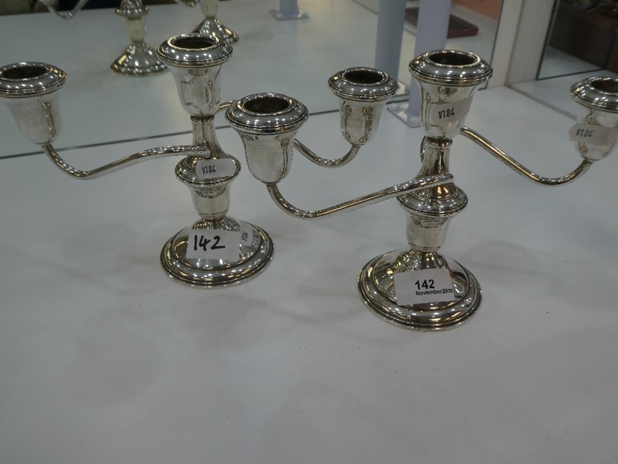 A pair of silver candelabras marked 'Lord Silver inc silver weighted'