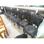 A set of eight black painted dining chairs having pierced splats