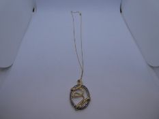Modern 14k abstract design oval pendant, set with 79 diamond chips on a 14K yellow gold fine chain,
