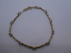 Pretty 9ct yellow gold bracelet set with 9 pale blue stones, marked 375