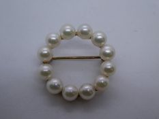 9ct circular brooch decorated with seed pearls, marked 375 on bar, approx. 2.5cm