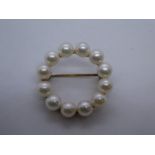 9ct circular brooch decorated with seed pearls, marked 375 on bar, approx. 2.5cm