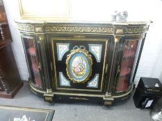 A Victorian ebonised Credenza having profuse gilt metal decoration, the central door having Sevres s