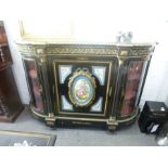 A Victorian ebonised Credenza having profuse gilt metal decoration, the central door having Sevres s