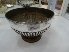 A silver Edwardian small punch bowl, with half reeded body on a raised spreading pedestal foot, also