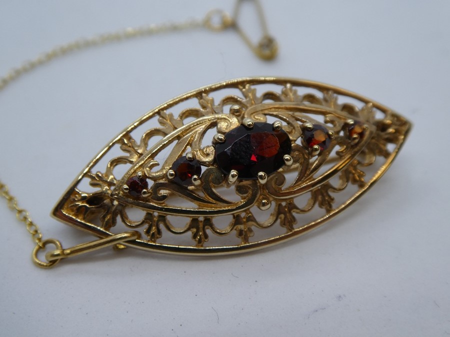 9ct Yellow gold oval brooch set with faceted garnets, marked 375 on pin, with safety chain, approx.. - Image 2 of 5