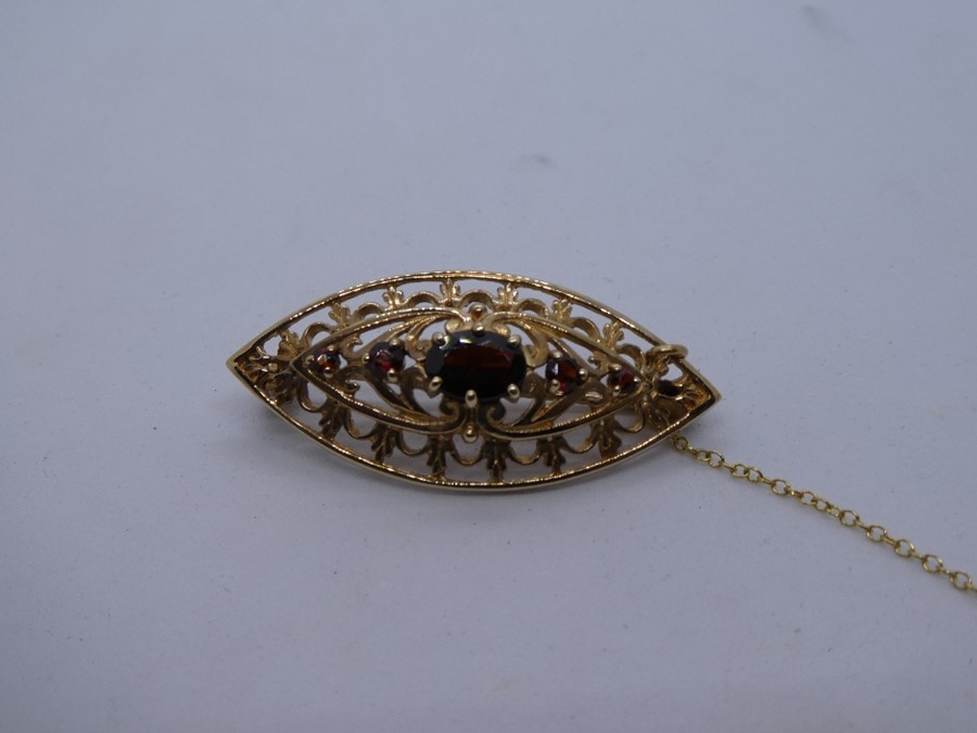 9ct Yellow gold oval brooch set with faceted garnets, marked 375 on pin, with safety chain, approx.. - Image 5 of 5