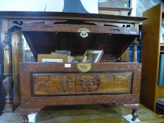 A Chinese carved camphor wood blanket box containing a quantity of pictures