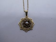 9ct yellow gold neck chain, marked 375, hung with an unmarked circular pendant set with seed pearls