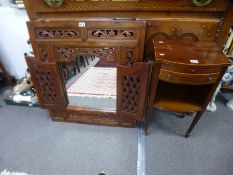 A carved frame with a pair of doors enclosing mirror and a mahogany table