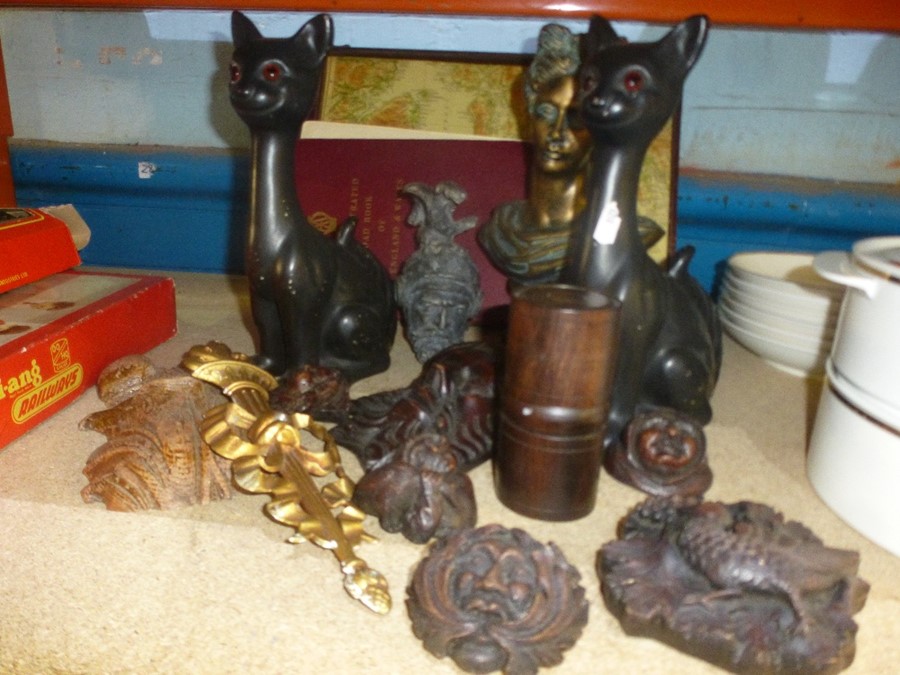 A small collection of decorative carvings, a map book and another book