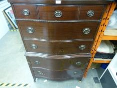 A mid century mahogany tallboy having serpentine front with five long drawers