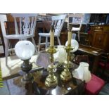 Two oil lamps with shades, two brass candlestick lamps, and two other lamps with shades.