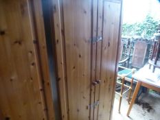 Two modern pine wardrobes and a chest of drawers