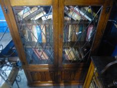 A reproduction oak bookcase having leaded glass doors