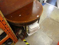 An antique mahogany demi line fold over card table having crossbanded decoration on square tapered l