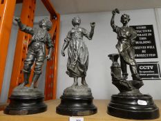 A pair of spelter figures of lady and gent and one of other of blacksmith